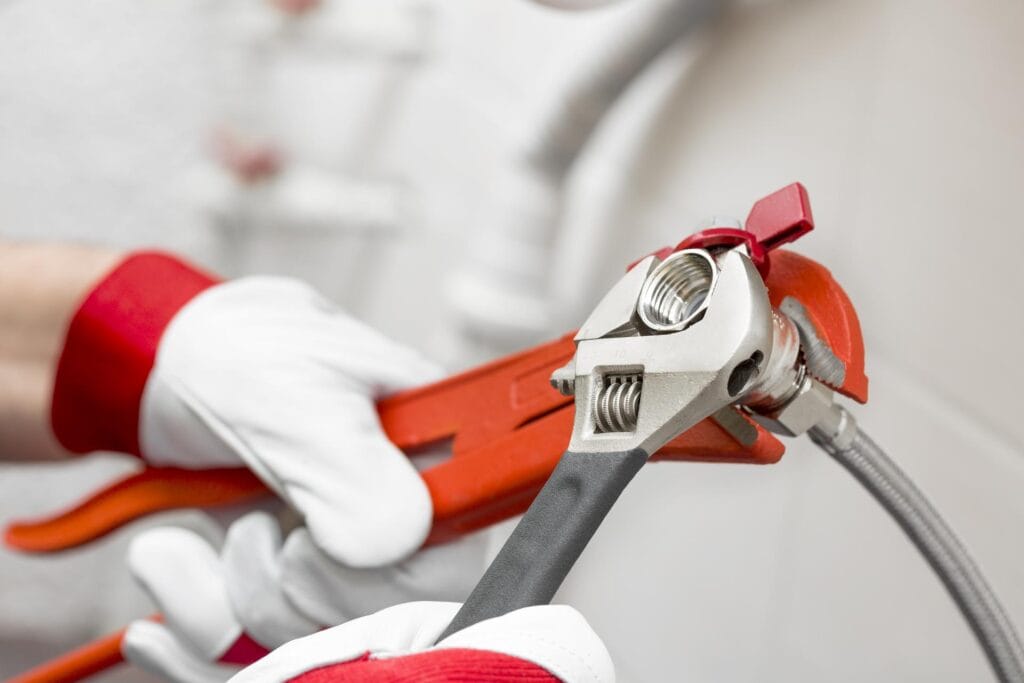 Plumber holding pipe wrenches for an emergency repair in Plantation