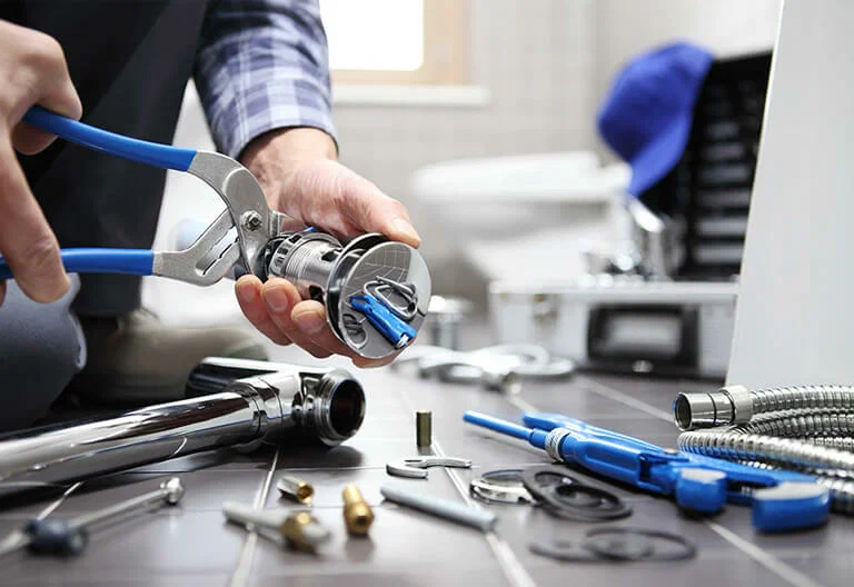 Technician repairing a plumbing fixture with professional tools in Plantation