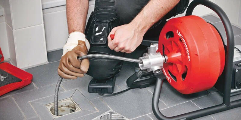 Plumber using a drain-cleaning machine in Plantation