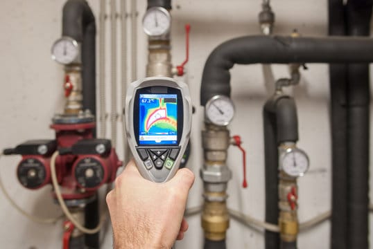 Plumber using a thermal imaging camera to inspect pipes in Plantation