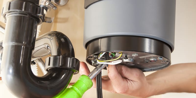 Technician repairing the heating element of a water heater in Plantation