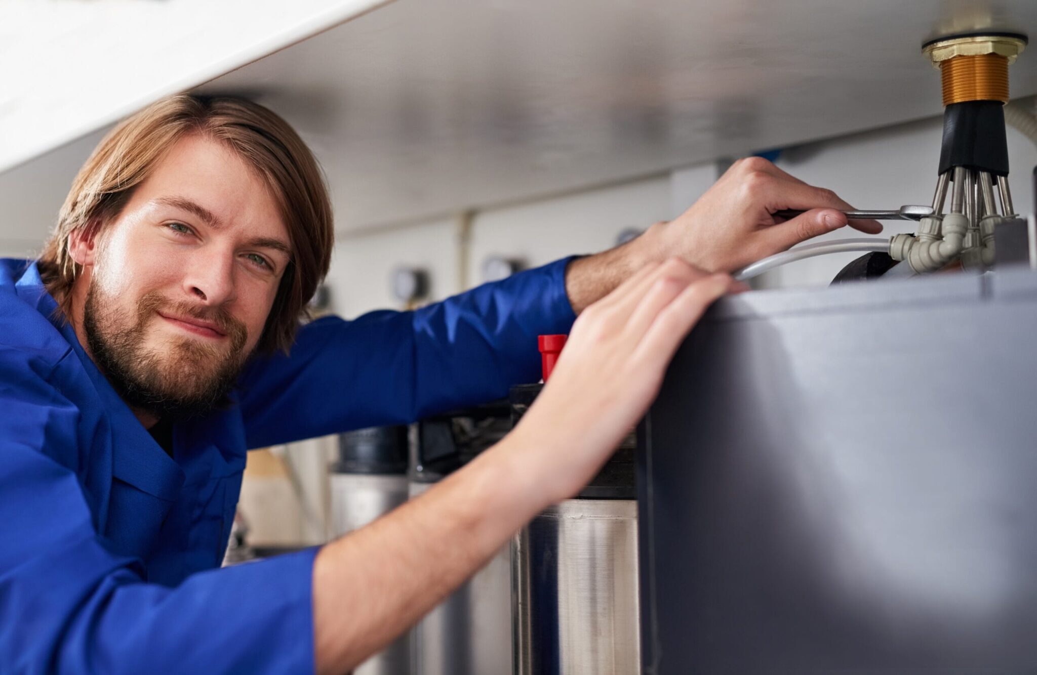 Technician servicing a residential water heater tank in Plantation